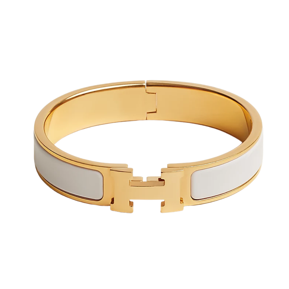 The iconic Hermès Clic H bracelet in white enamel with gold-plated hardware. Features the signature H-clasp closure and a wide, smooth enamel band — a timeless luxury accessory.