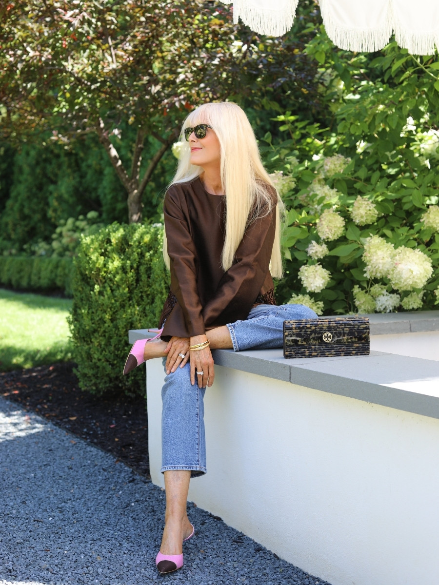 Mary wearing a chocolate-brown Tuckernuck top with Pistola jeans, pink vintage Prada heels, a vintage Tory Burch bag and Ray-Ban sunglasses.